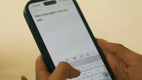 ידיים מחזיקות טלפון עם הודעת טקסט שנכתבת, בזמן אמת
